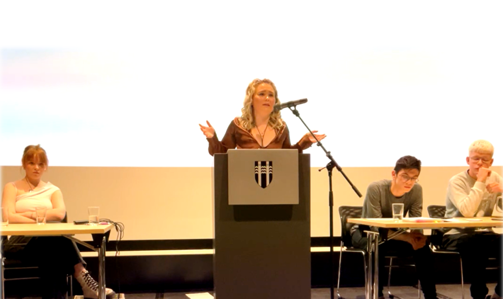 Krista Sól ræðumaður kvöldsins í ræðustól. Skjáskot.